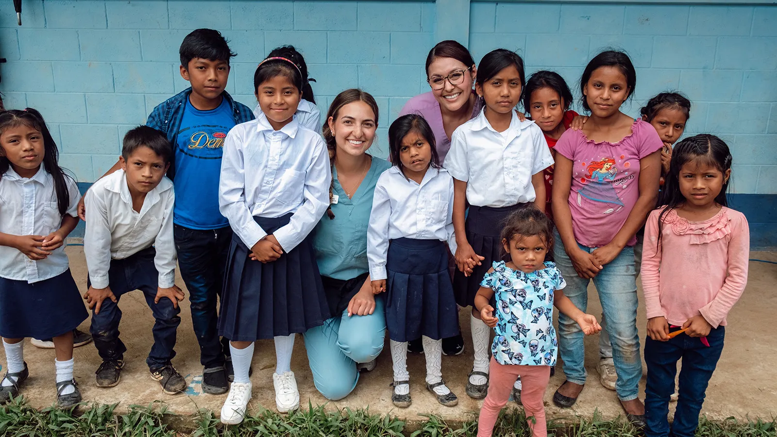 students and young patients posing outside clinic