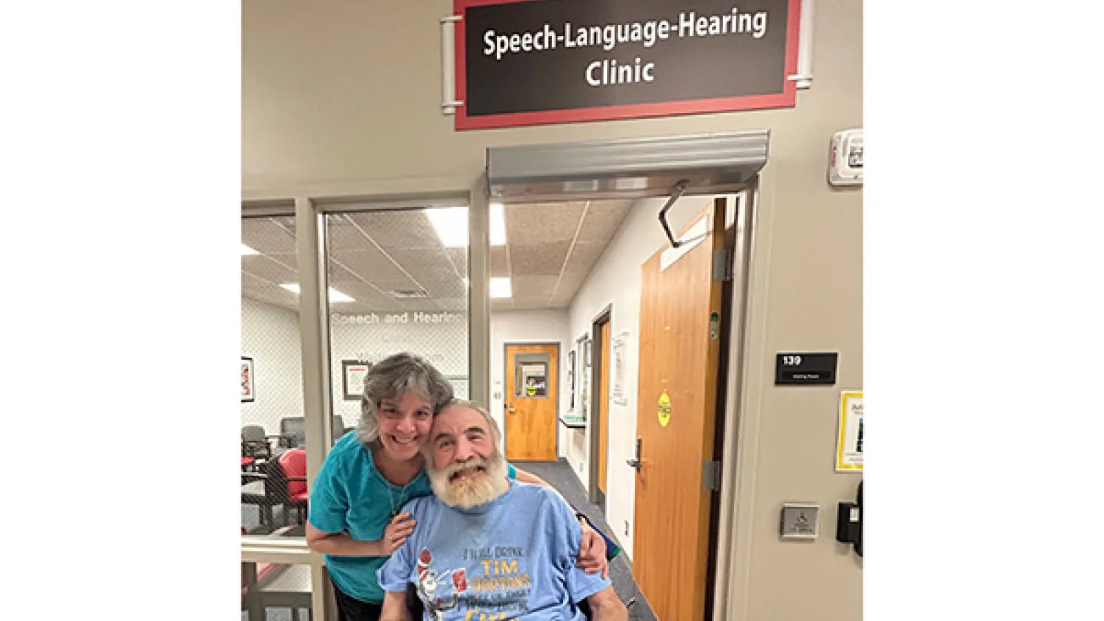 Father John and Elaine Stavropoulos posing in front of clinic entrance