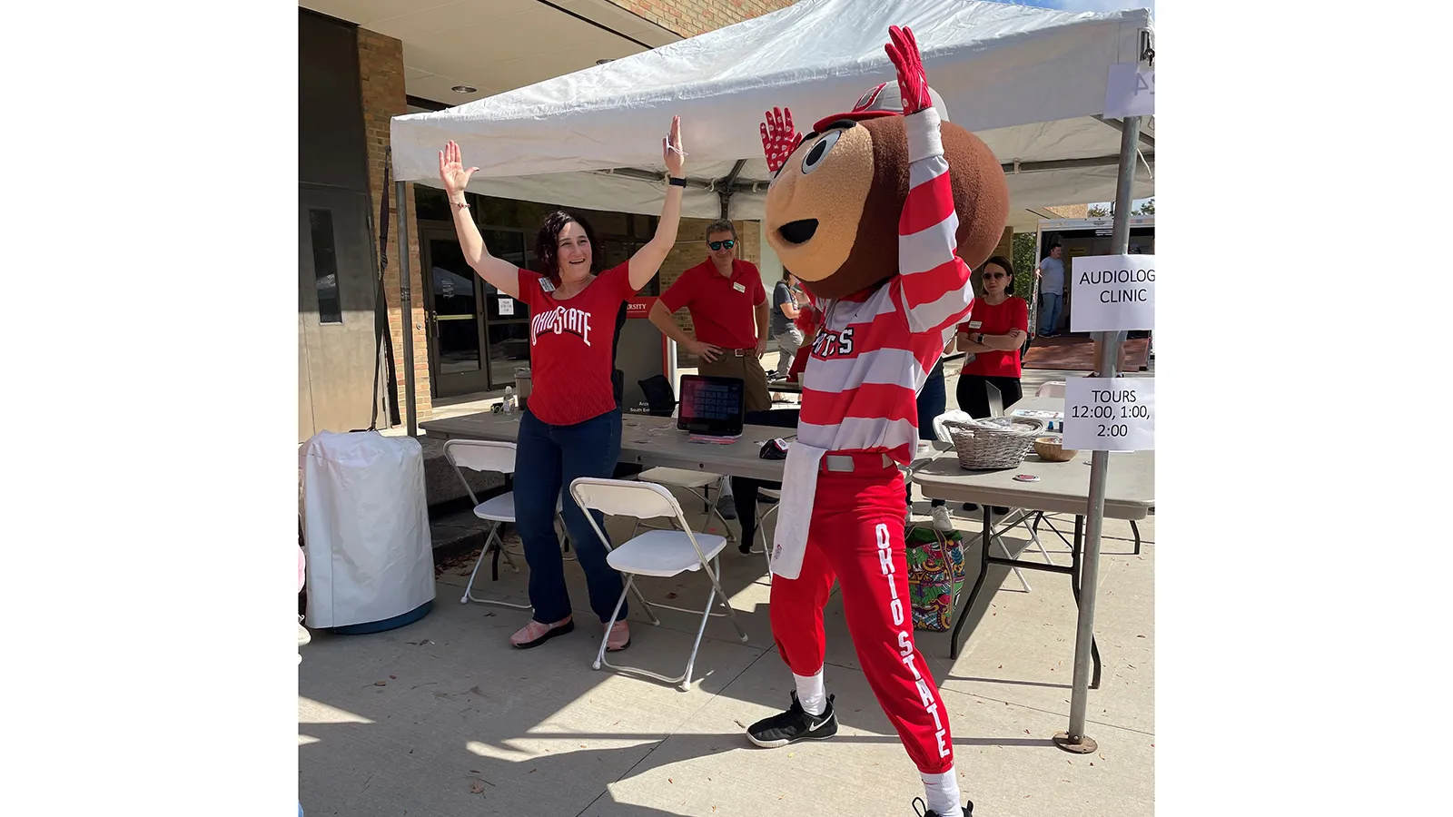 Brutus posing with faculty under tent