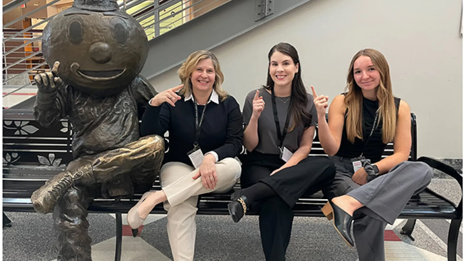 Erika Hagen, Nicole Viola, and Courtney Jewell posing on bench next to Brutus statue