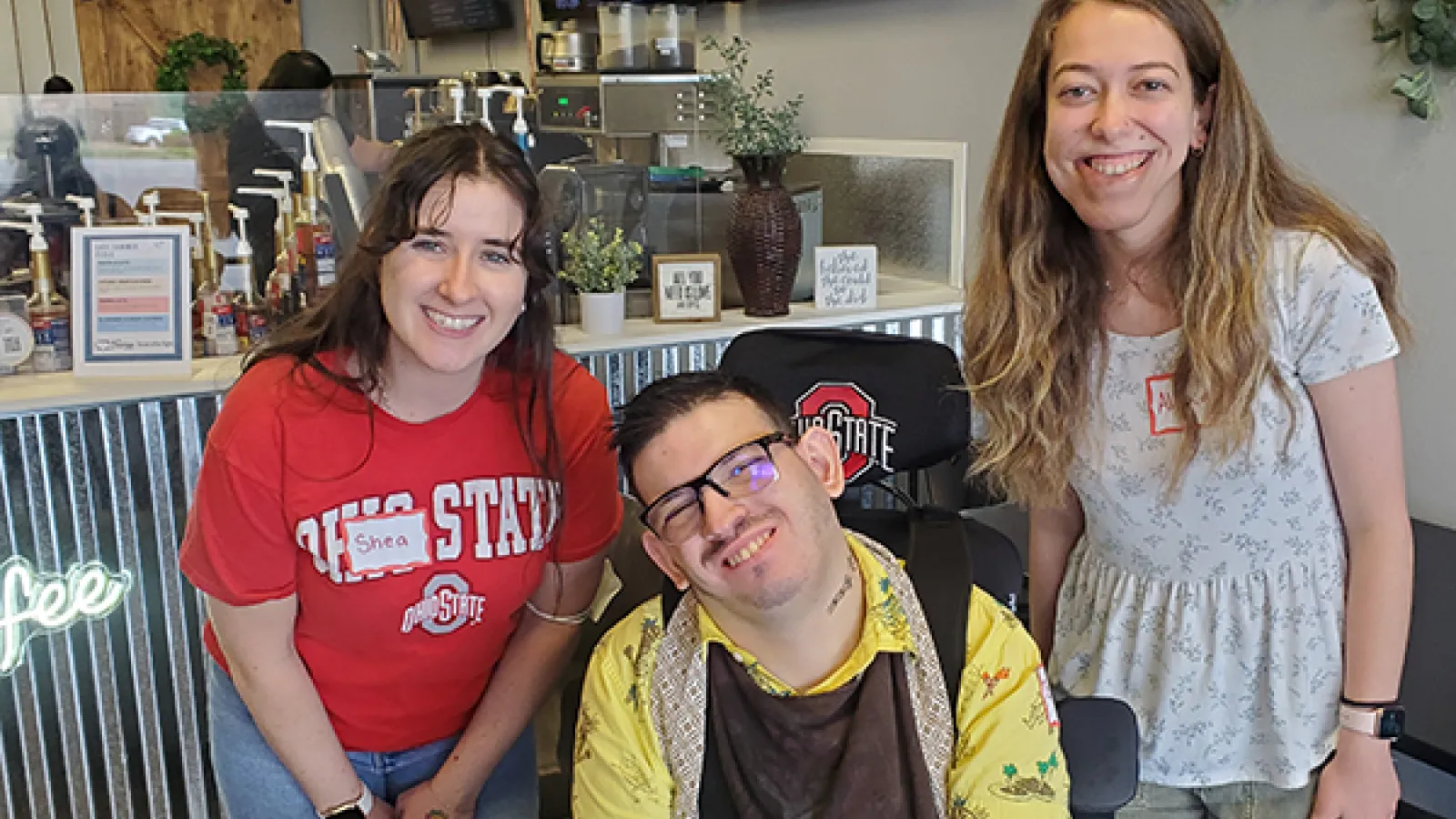 Shea, Brady, and Alexa pose in front of coffee shop counter