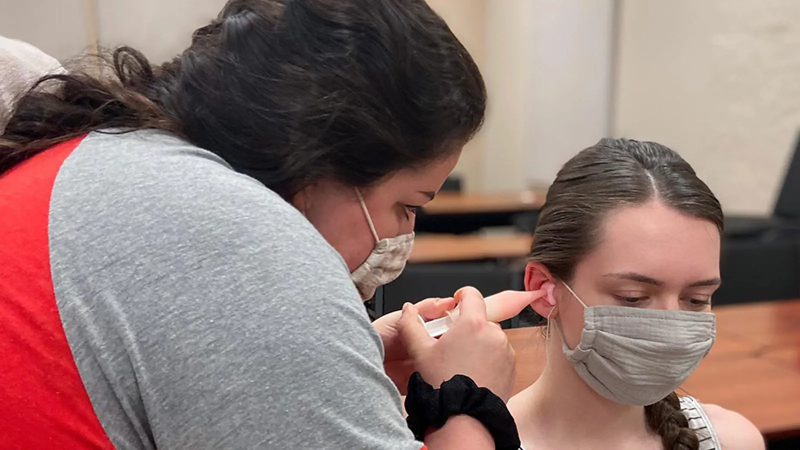 student performing ear mold impression on patient