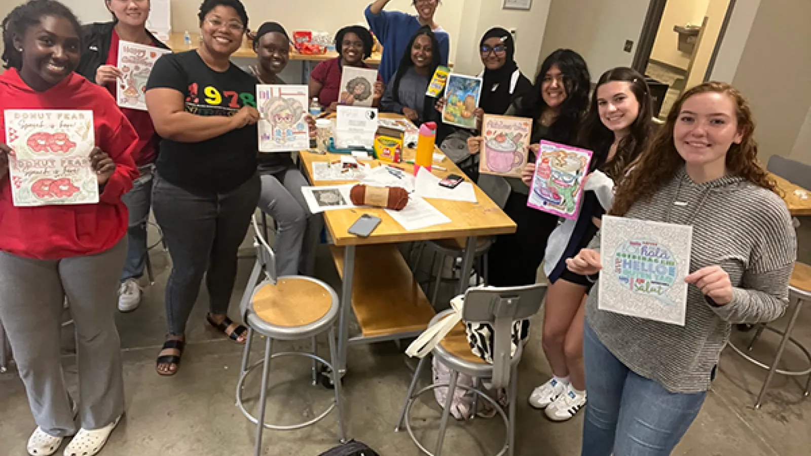 Group photo of students holding up artwork