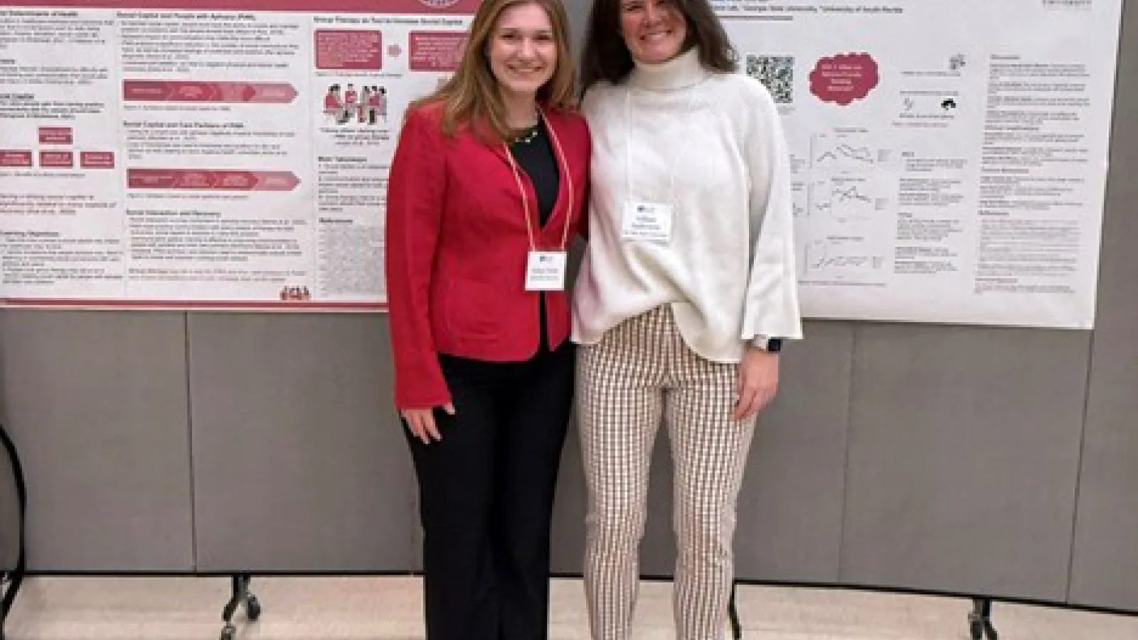 Two students posing in front of research posters