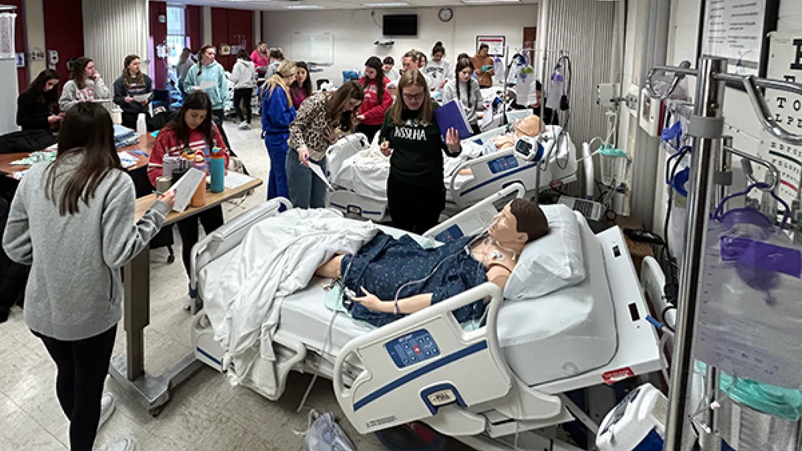 Wide shot of students engaged in simulated hospital environment