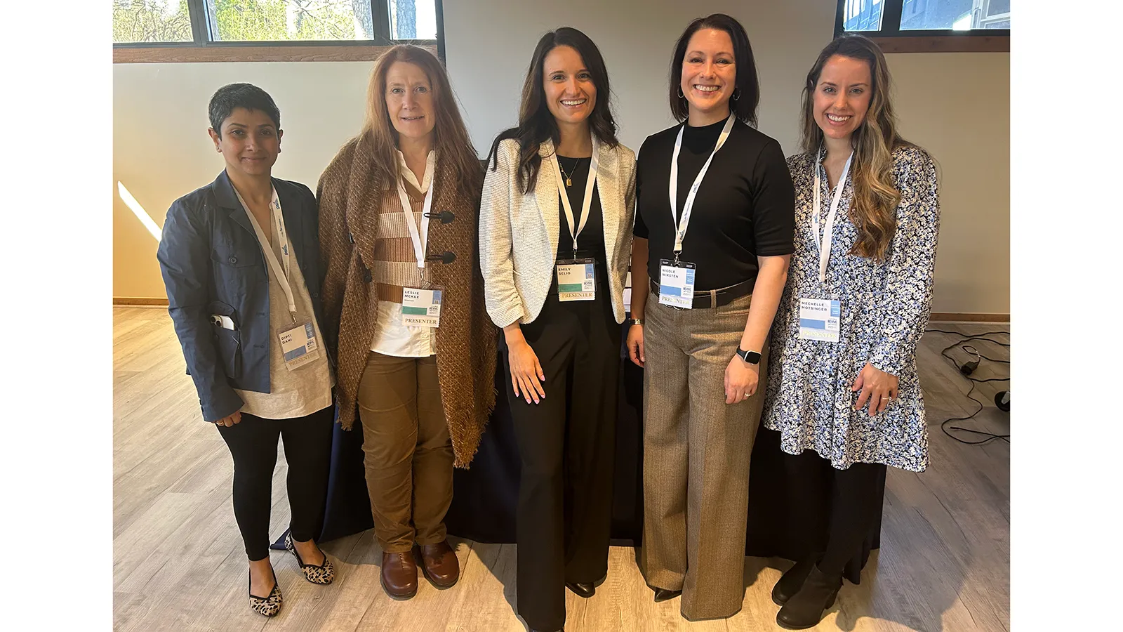 Group photo of 5 professionals posing at conference