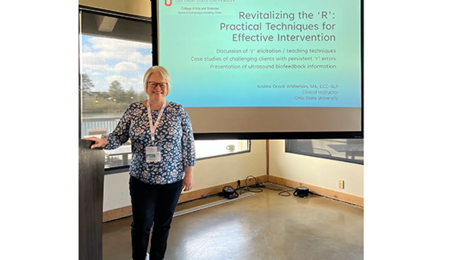 Nadine Whiteman posing in front of presentation screen: "Revitalizing the 'R': Practical Techniques for Effective Intervention