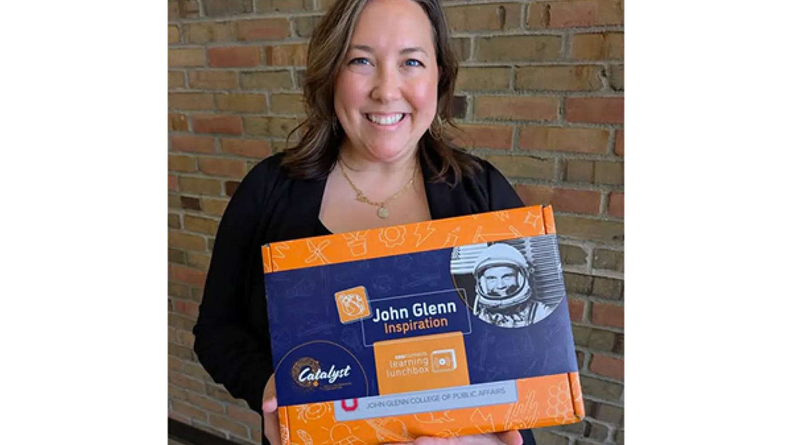 Bridget Chapman holds inspiration kit with picture of John Glenn in astronaut gear