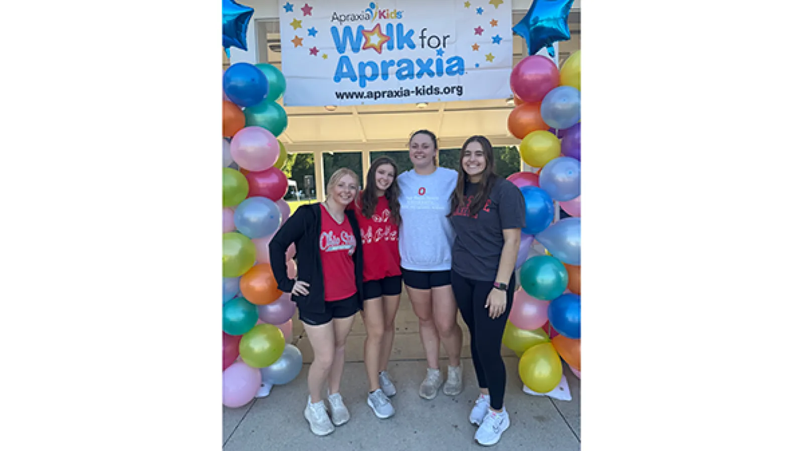 Group of students with colorful balloon towers and Apraxia sign