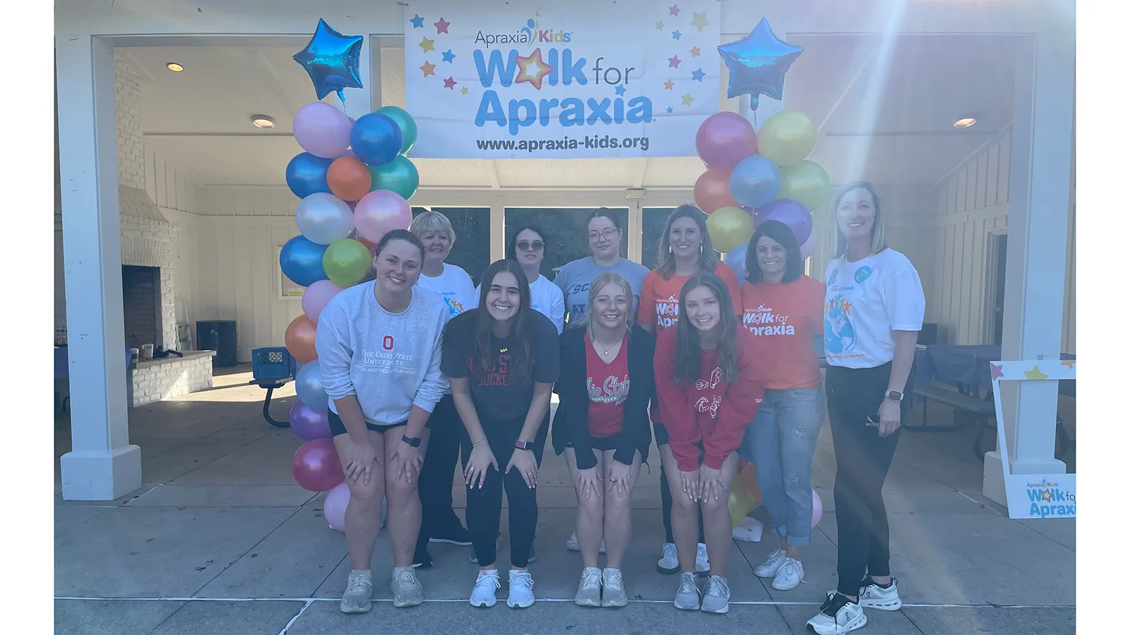group photo students with balloon towers and apraxia sign