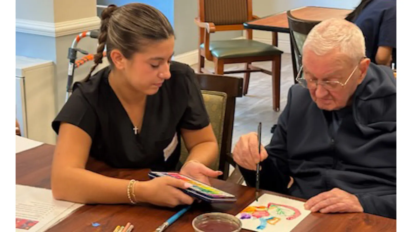 student in scrubs paints with patient