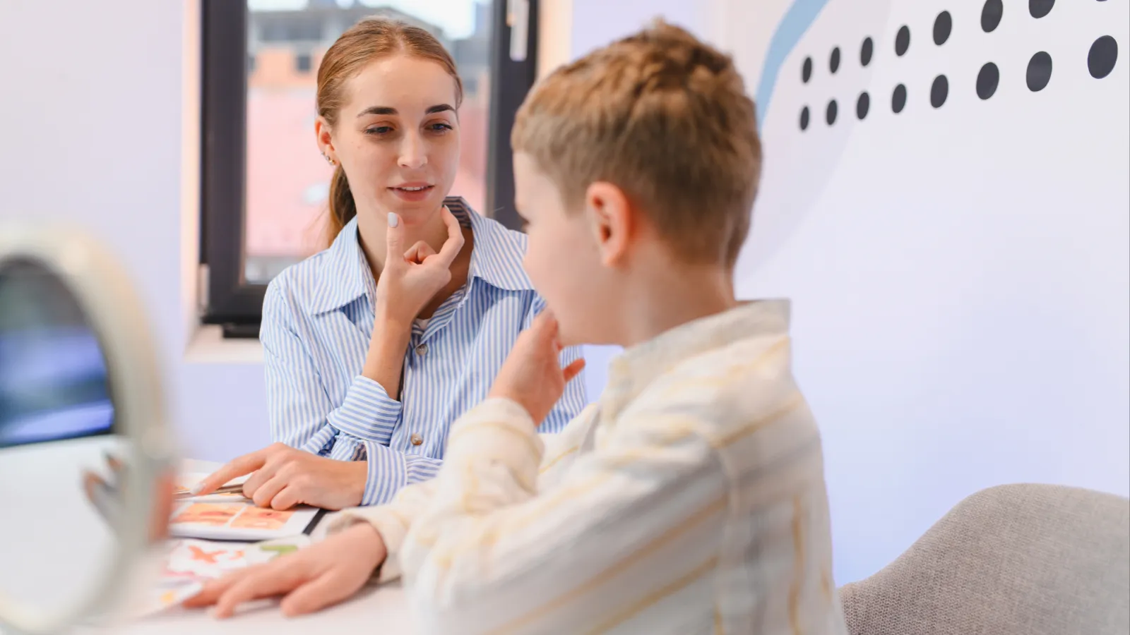 Young boy receiving speech therapy with a female therapist 