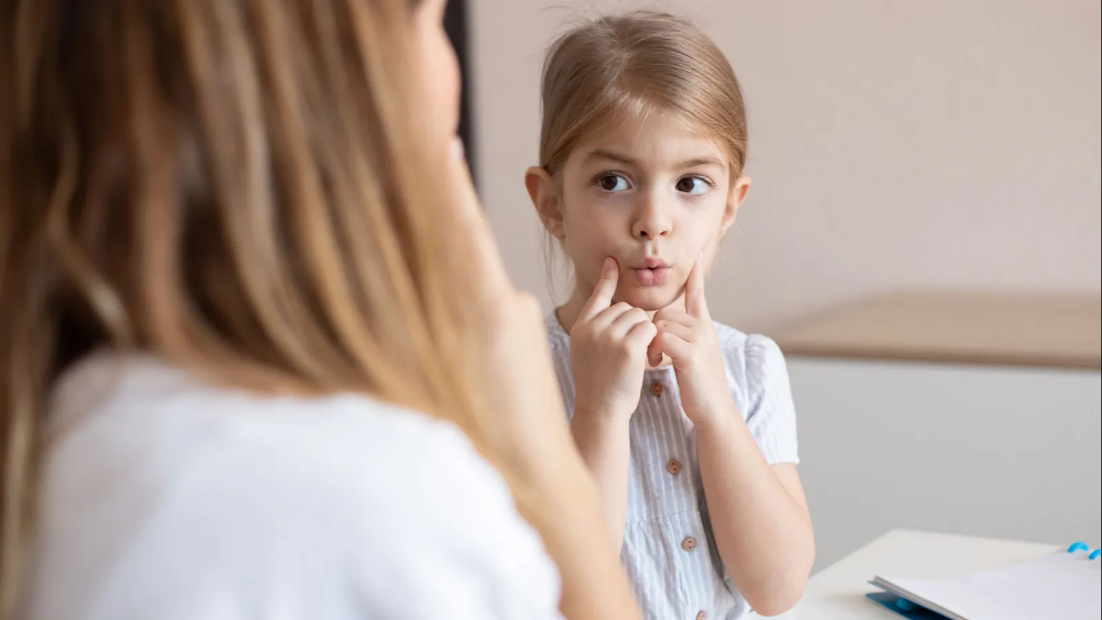 Speech therapist practice therapy for child with motor speech disorders.