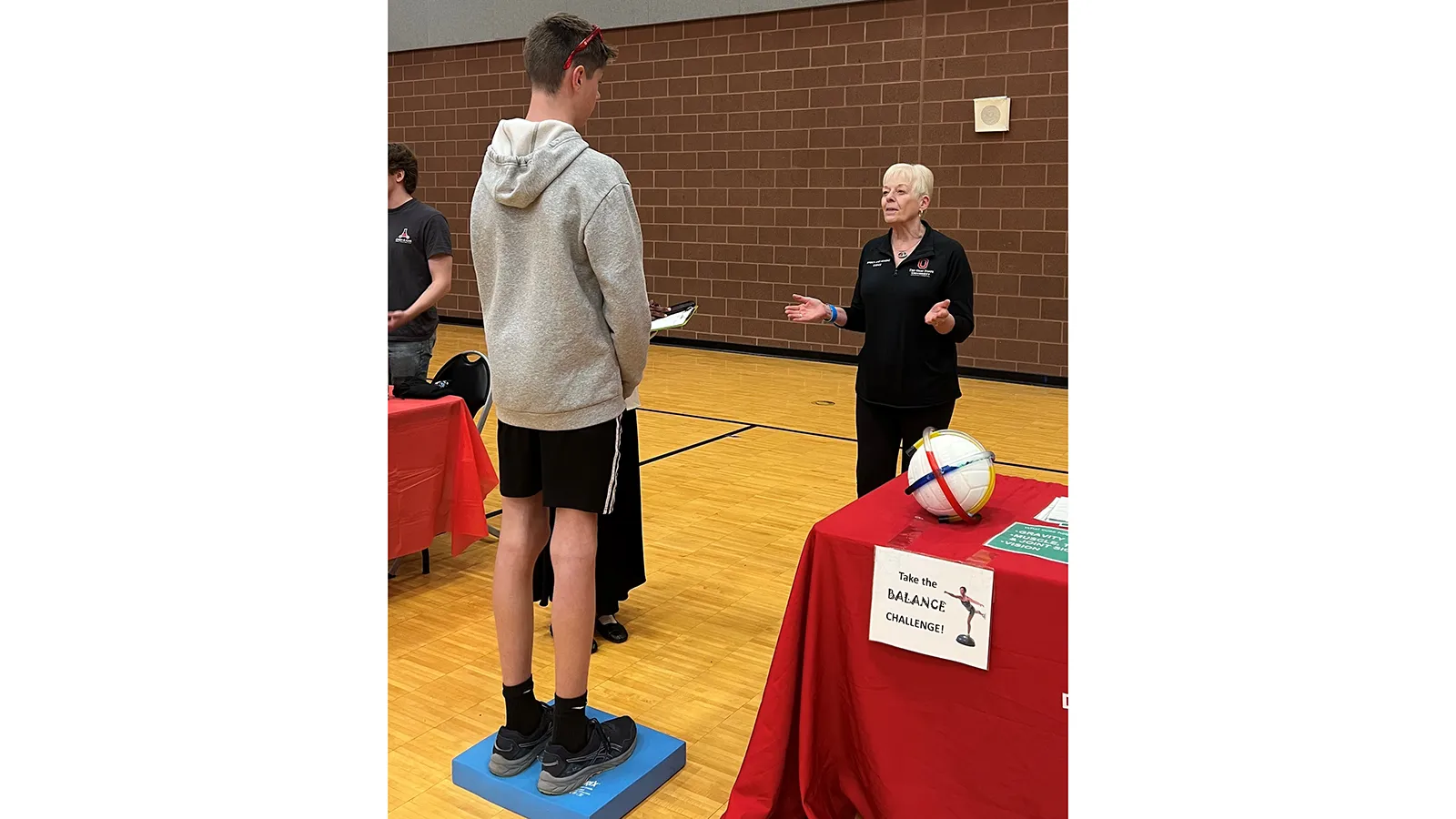 young person standing on a device and a sign that says take the balance challenge