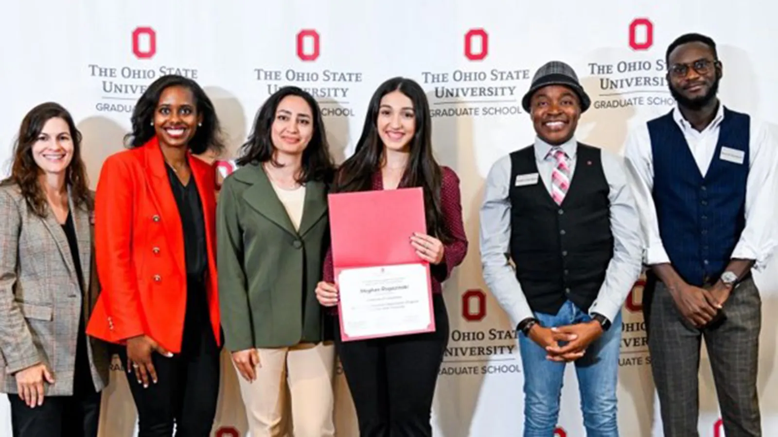 group photo with Meghan Rogozinski displaying award