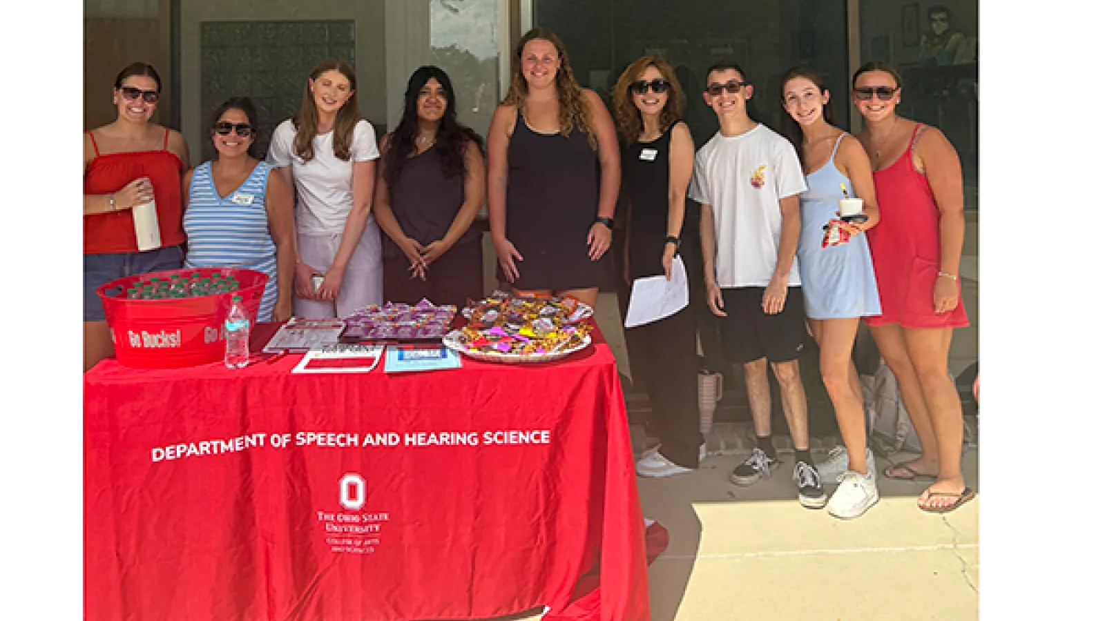 Group photo of students, faculty, and staff behind snack table