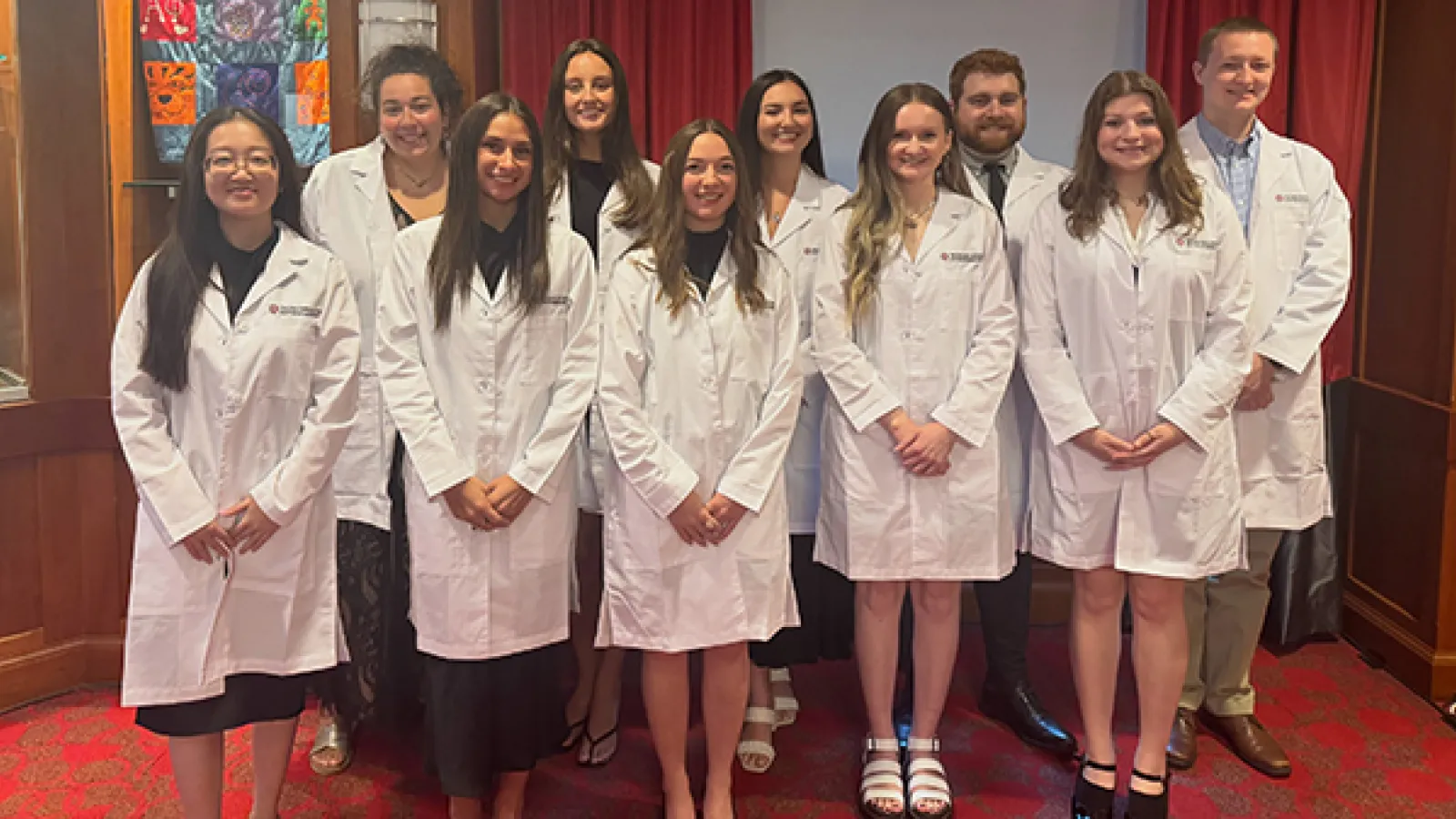 Group photo of students in white coats
