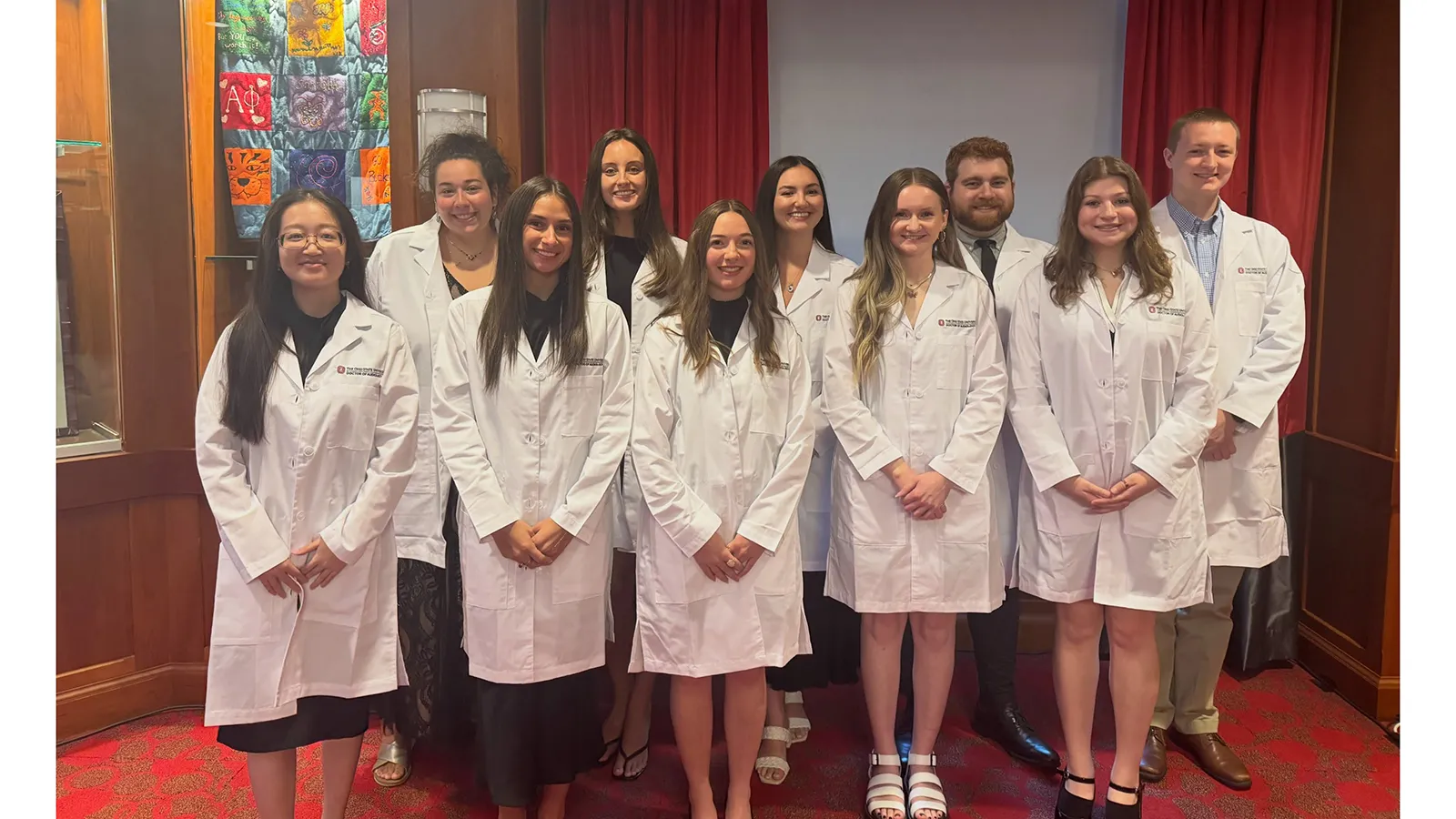 Group photo of students in white coats