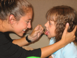 Student clinician examining child's mouth