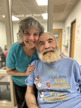 Father John and Elaine Stavropoulos posing in front of clinic entrance