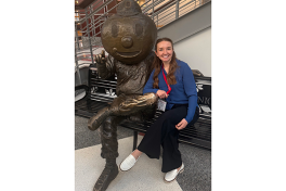 Courtney Jewell seated by Brutus statue on bench