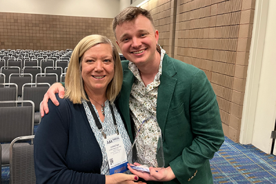 Christina Roup and Riley DeBacker holding an award