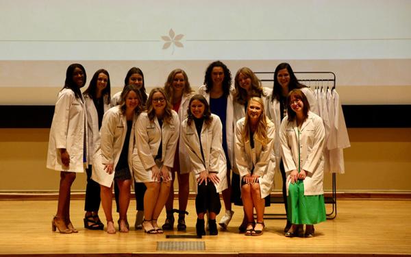 Audiology students in white coats