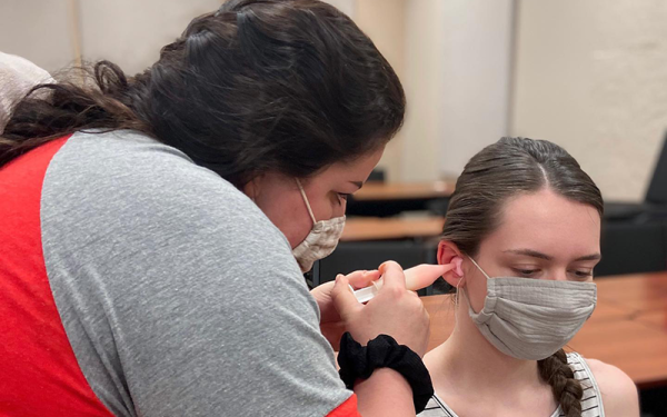 student performing ear mold impression on patient