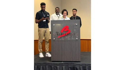 Family of four standing behind podium