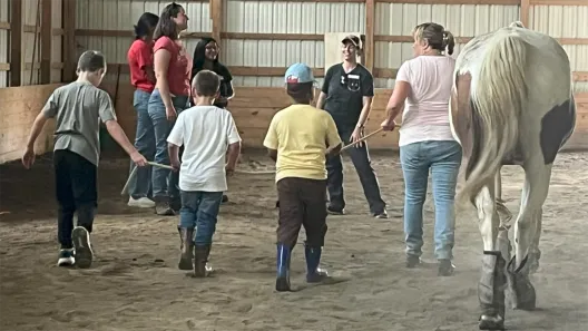 children and adults leading horses around a ring