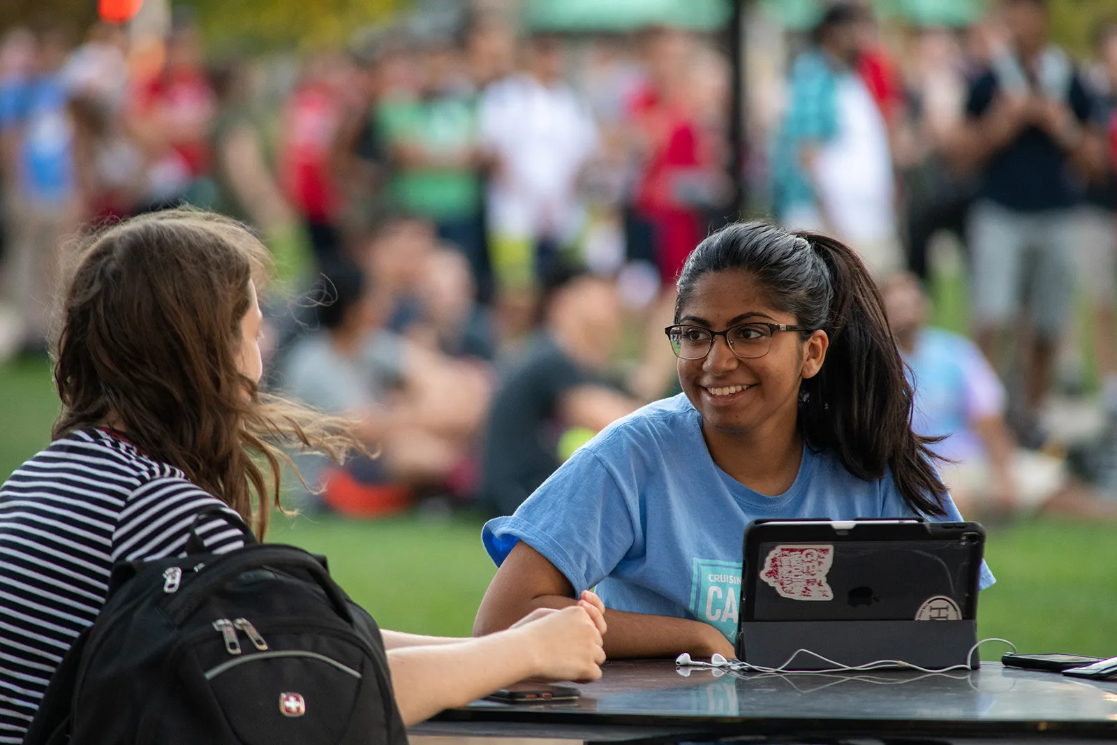 Students chatting with laptop outdoors