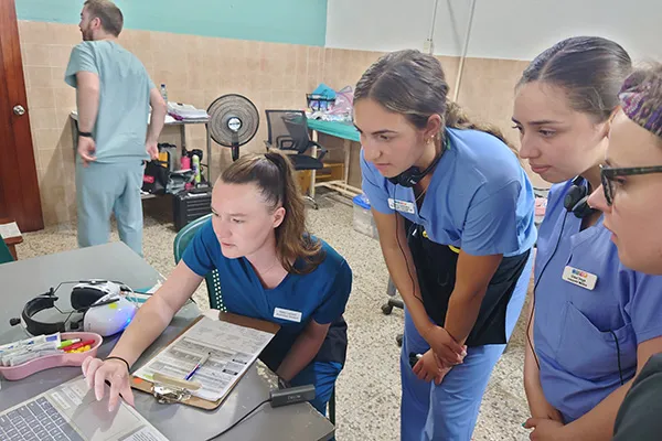 Students in scrubs working in clinic