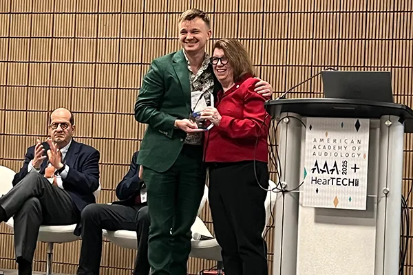 Dr. Whitelaw presenting award to Riley on stage