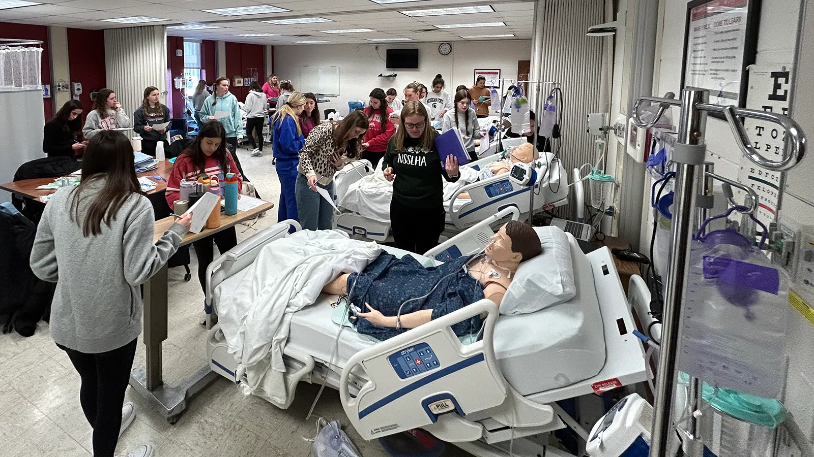 Wide shot of students engaged in simulated hospital environment