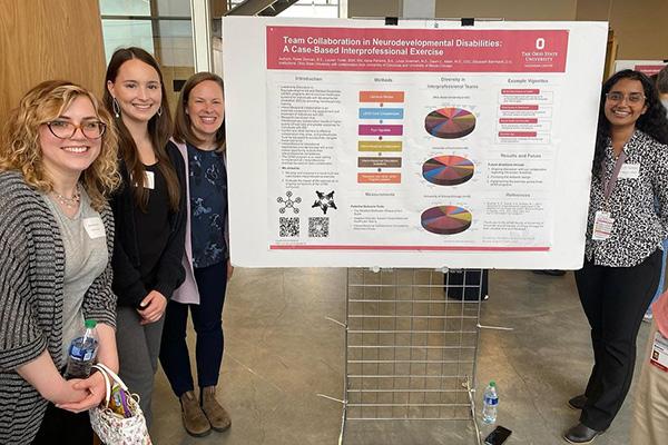 Alicia Parsons and students posing around large research poster