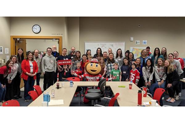 large group of event attendees surrounded by Brutus mascot
