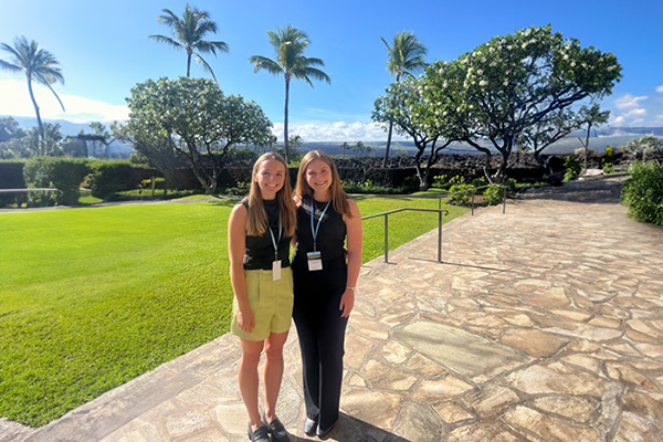 Courtney Jewell and Grace Terry standing in front of palm trees