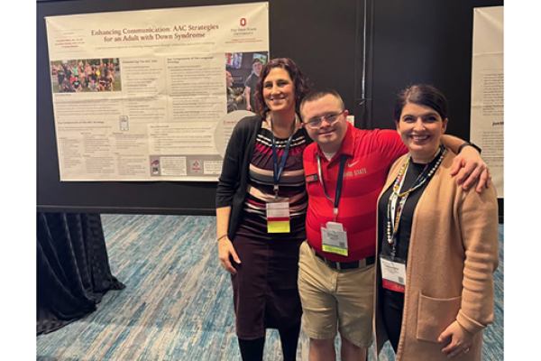 3 people posing in front of research poster