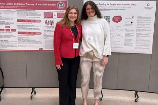 Two students posing in front of research posters