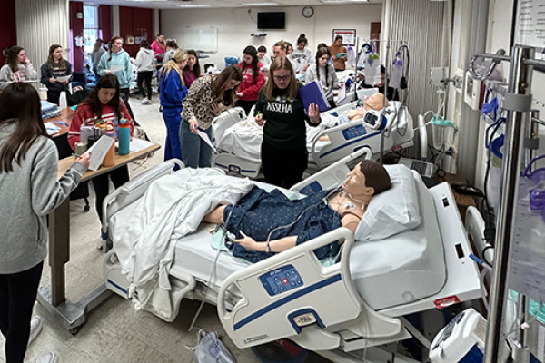 Wide shot of students engaged in simulated hospital environment