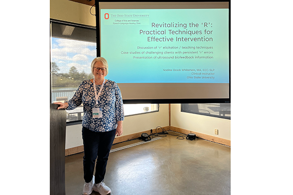 Nadine Whiteman posing in front of presentation screen: "Revitalizing the 'R': Practical Techniques for Effective Intervention