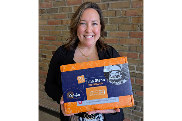 Bridget Chapman holds inspiration kit with picture of John Glenn in astronaut gear