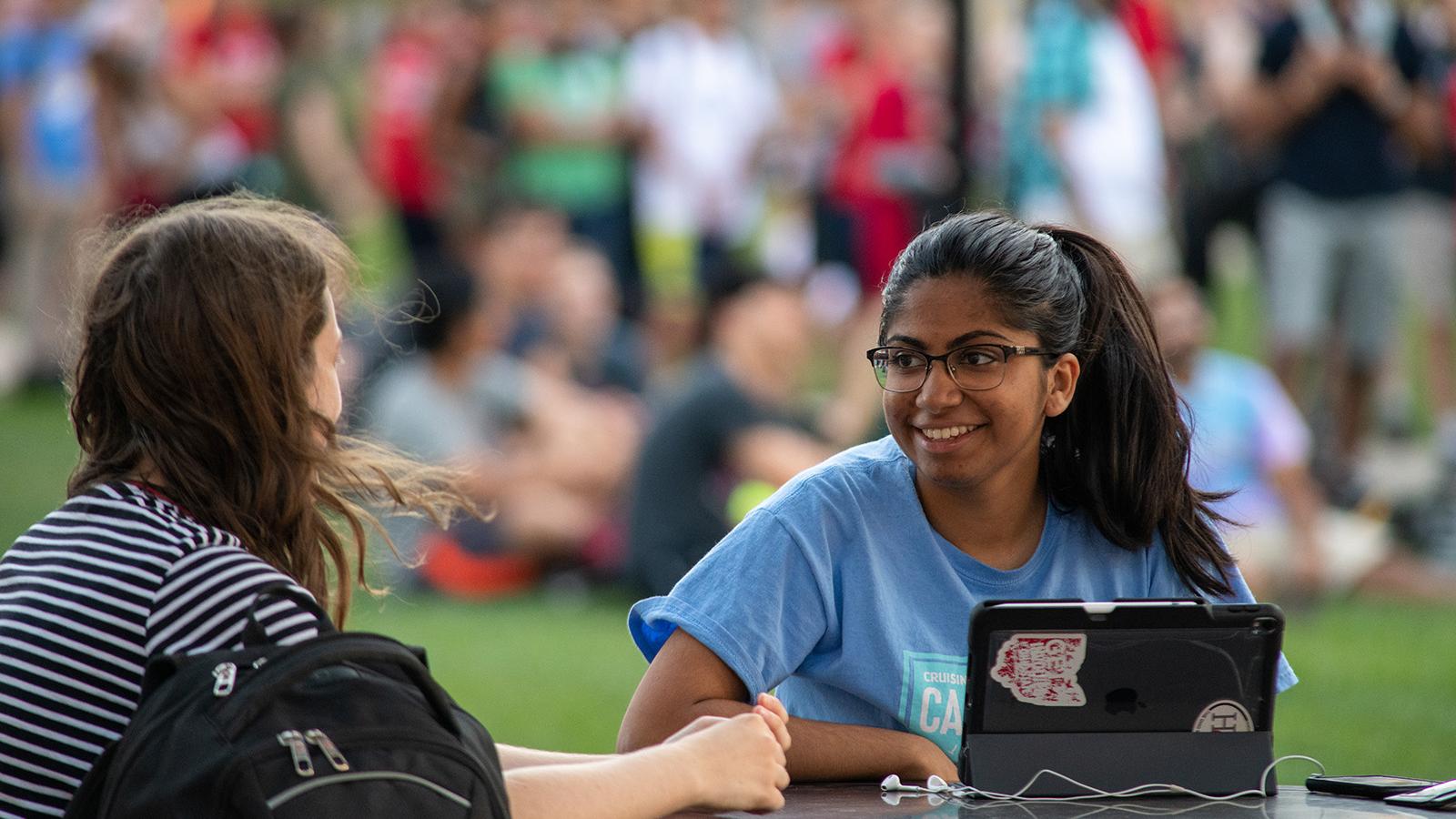 Students chatting with laptop outdoors