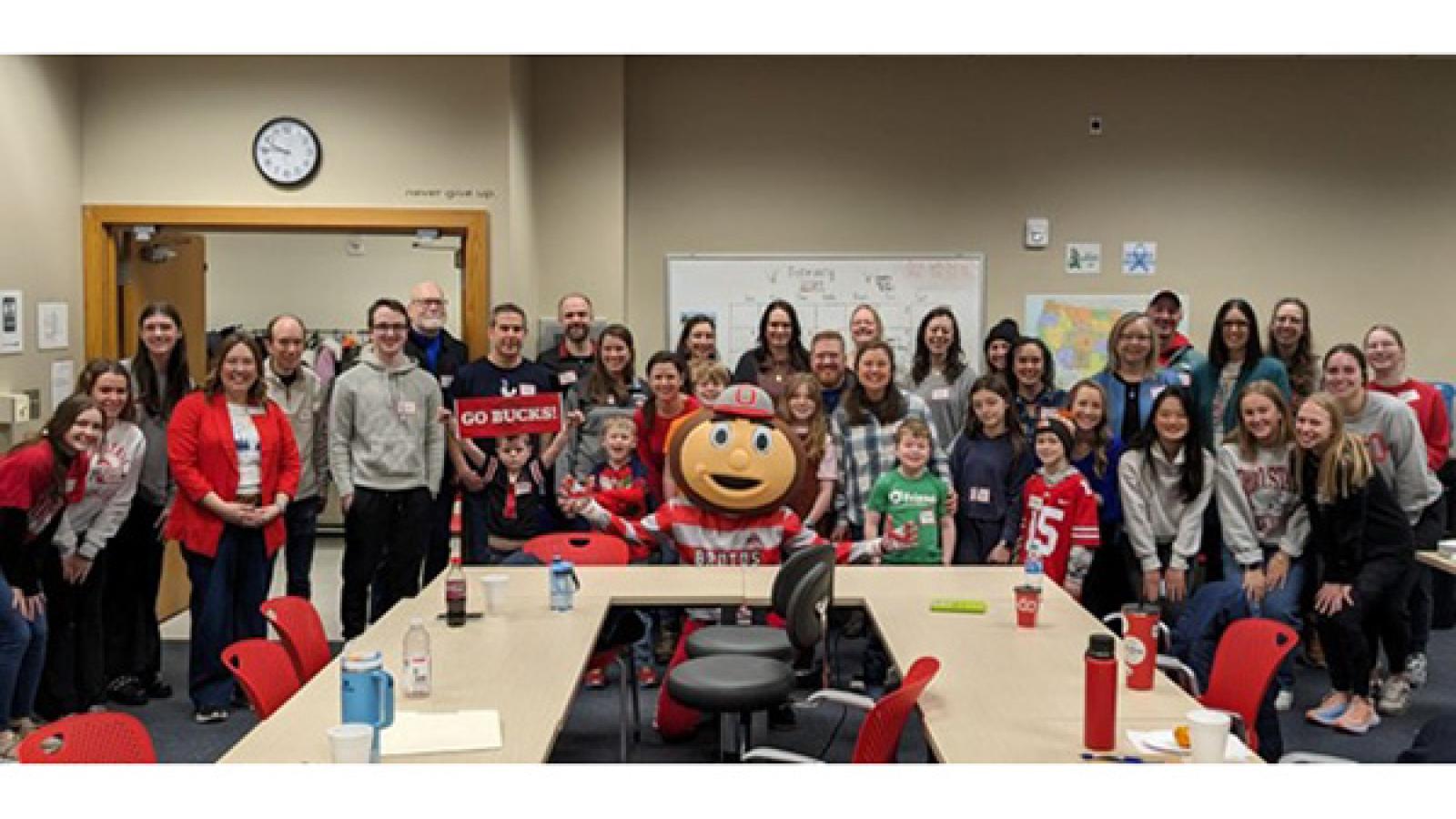 large group of event attendees surrounded by Brutus mascot