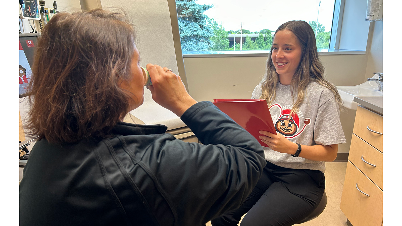 Student conducting screening to patient