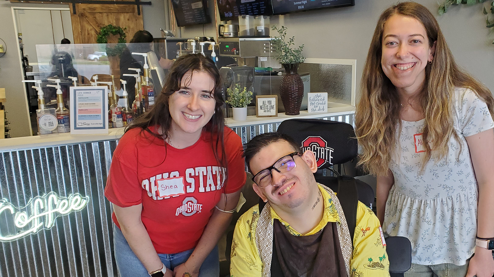 Shea, Brady, and Alexa pose in front of coffee shop counter