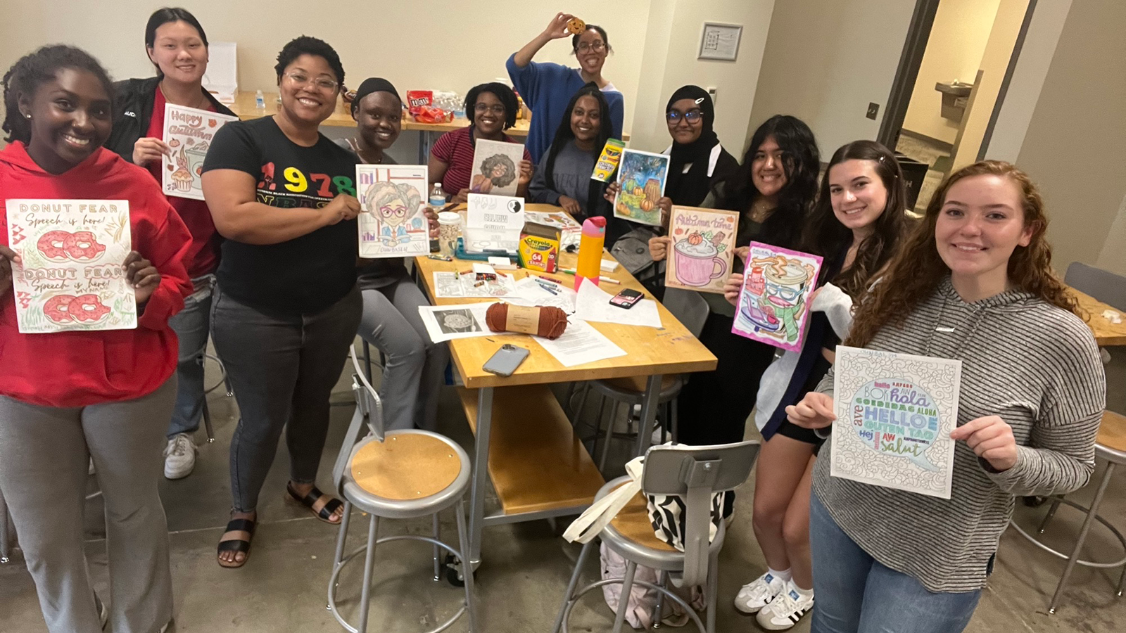 Group photo of students holding up artwork