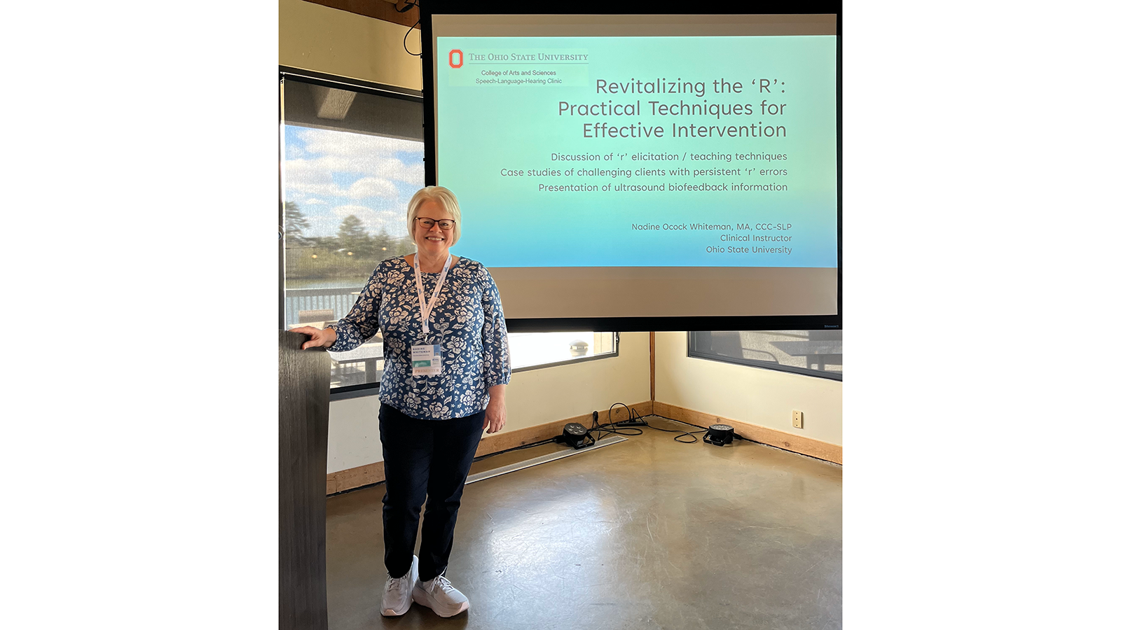 Nadine Whiteman posing in front of presentation screen: "Revitalizing the 'R': Practical Techniques for Effective Intervention