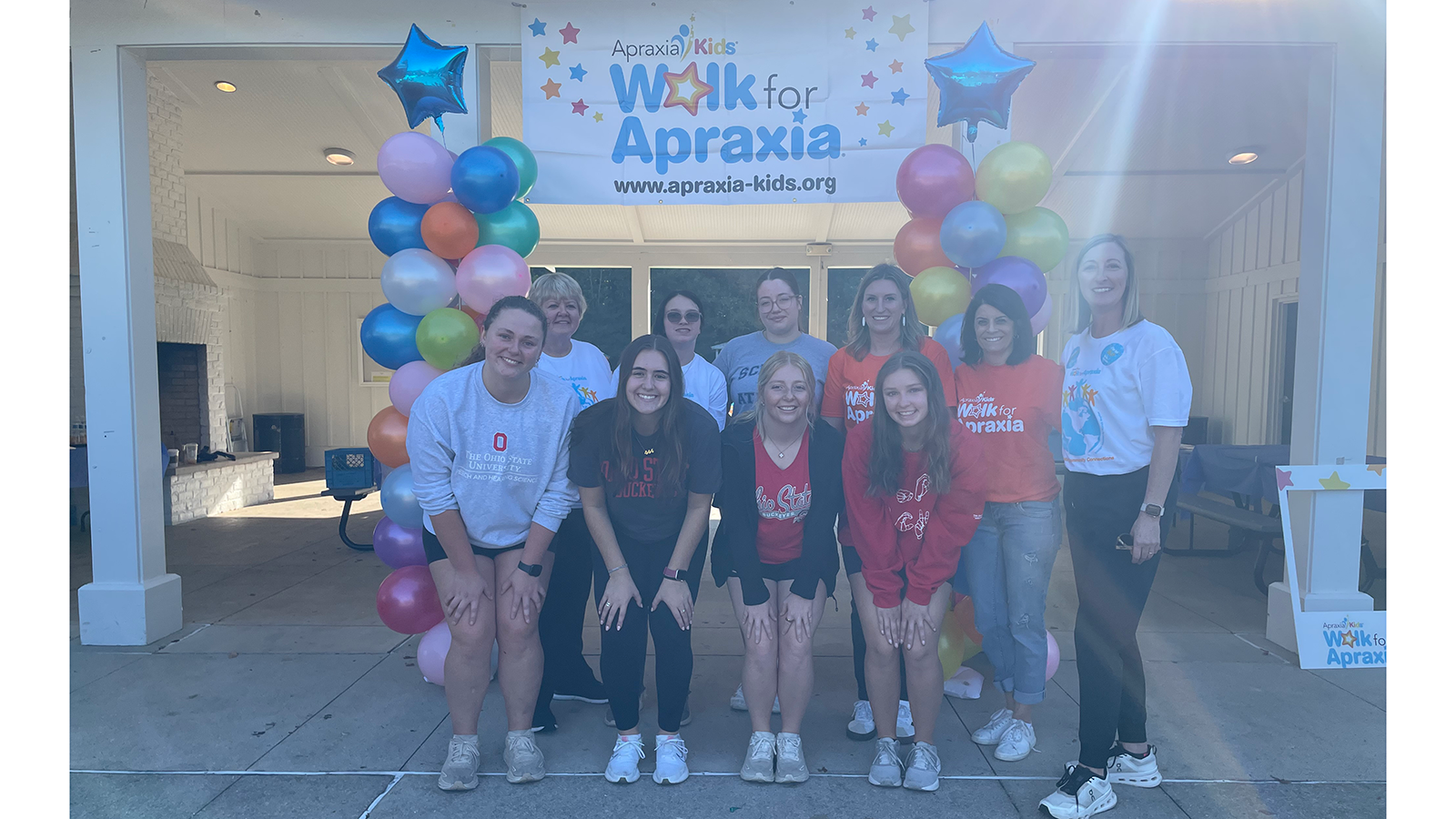 group photo students with balloon towers and apraxia sign