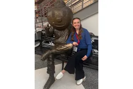 Courtney Jewell seated by Brutus statue on bench